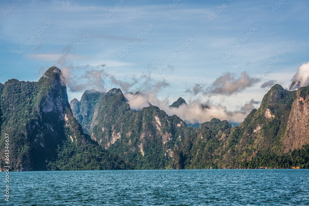 Beautiful nature rock mountains cliff with mist flow and raining fog in the morning in Ratchaprapa Dam at Khao Sok National Park, Surat Thani Province, Thailand. Asia tourism location.