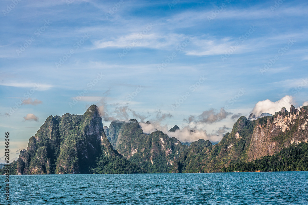 Beautiful nature rock mountains cliff with mist flow and raining fog in the morning in Ratchaprapa Dam at Khao Sok National Park, Surat Thani Province, Thailand. Asia tourism location.