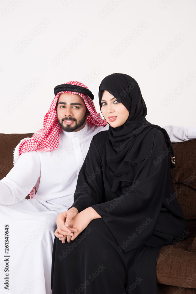 Arab couple sitting on sofa chair at home