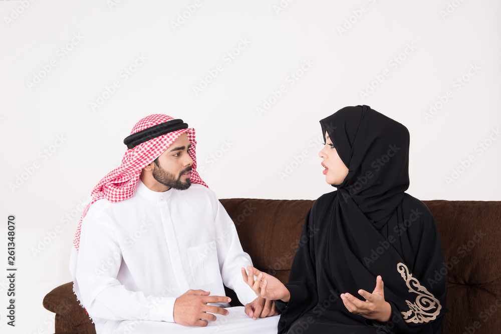 Arab couple fighting and discussing family issues while sitting on sofa chair at home
