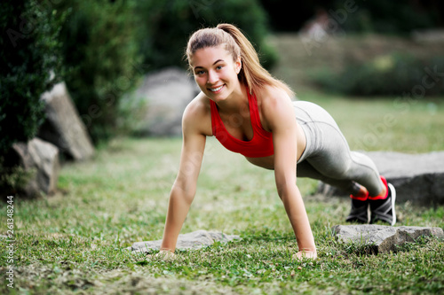 Fitness woman doing exercise outdoors in park.