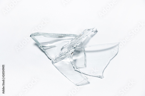 Parts of the broken cup jar glass isolated on white background. Pieces of sharp broken glass. Concept of danger.