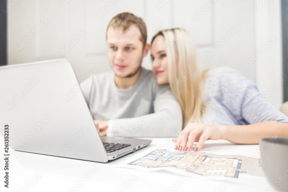 Lovely young couple, using a laptop and choosing a new apartment. Lovely young couple, using a laptop and choosing a new apartment.