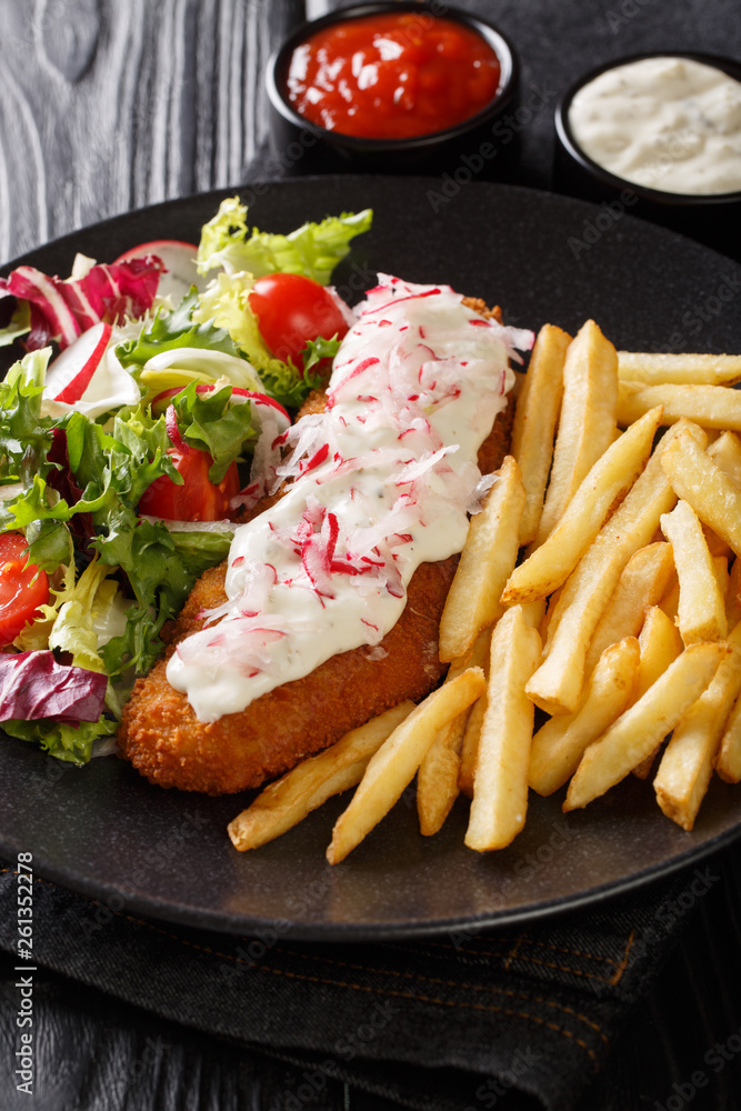 Lunch menu fried pollock with french fries and fresh salad close-up on a plate and sauce. vertical Lunch menu fried pollock with french fries and fresh salad close-up on a plate and sauce. vertical