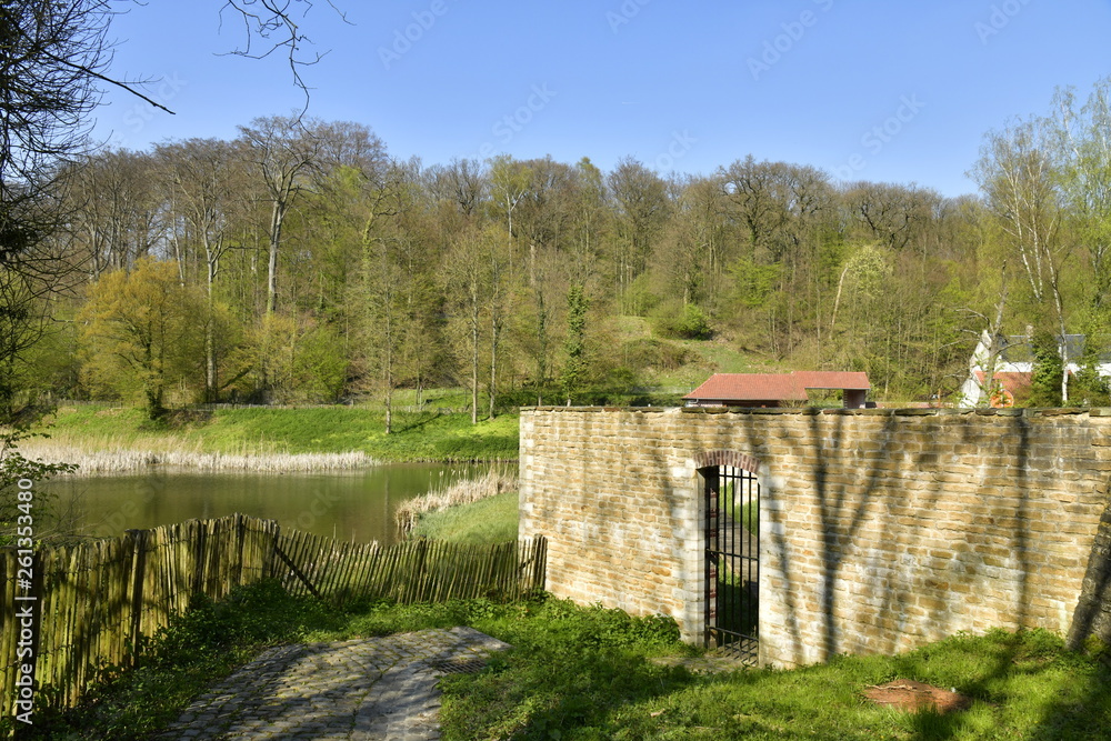 Porte grillagée dans le mur d'enceinte près du petit étang de Lange Gracht à l'abbaye du Rouge-Cloître à Auderghem Porte grillagée dans le mur d'enceinte près du petit étang de Lange Gracht à l'abbaye du Rouge-Cloître à Auderghem