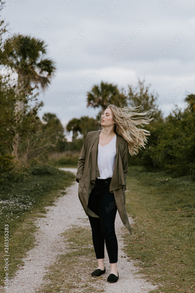 Pretty Young Beauty Woman Model with Gorgeous Long Blond Hair Blowing in the Wind Smiling for Portrait Shots Outside at the Park Pretty Young Beauty Woman Model with Gorgeous Long Blond Hair Blowing in the Wind Smiling for Portrait Shots Outside at the Park