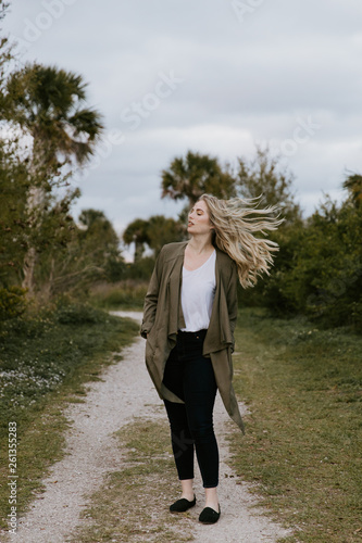 Pretty Young Beauty Woman Model with Gorgeous Long Blond Hair Blowing in the Wind Smiling for Portrait Shots Outside at the Park © MeganMahoneyPhotos