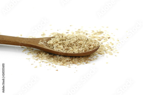 Wheat germ, the highly nutritious heart of the wheat kernel isolated on white. Wheat germ pile with wooden spoon isolated on white background, top view.