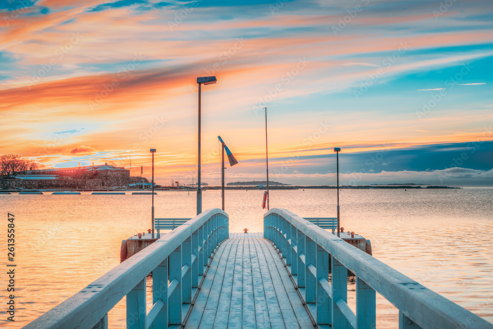 Obraz premium Old Frosted Wooden Boards Pier On Calm Water Of Lake Or River Or Sea At Evening Or Morning Time. Sunset Sunrise In Winter Season