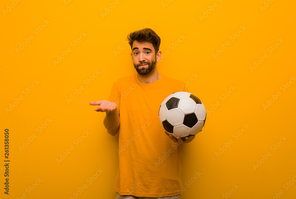 Young soccer player man confused and doubtful Young soccer player man confused and doubtful