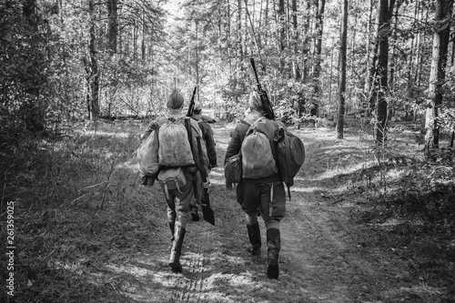 Two Re-enactors Dressed As World War II Russian Soviet Red Army Soldiers Marching Through Forest. Photo In Black And White Colors. Soldier Of WWII WW2 Times photo