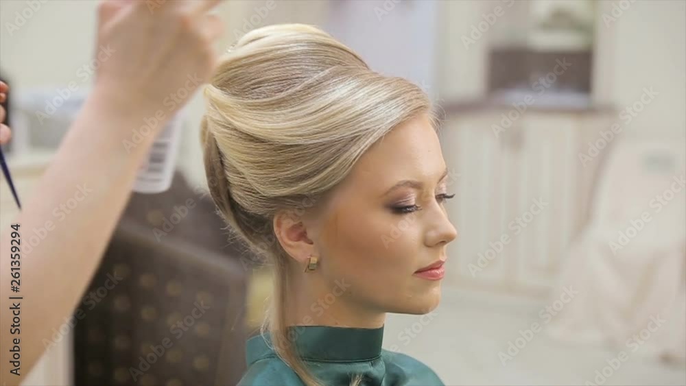 Hair master sprays varnish, makes curls, blonde, beauty salon, slow motion Hair master sprays varnish, makes curls, blonde, beauty salon, slow motion