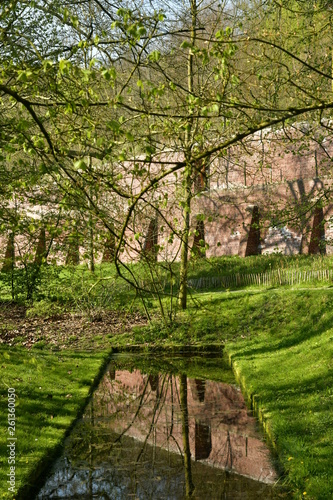 Mur d enceinte r  cemment restaur   se refl  tant dans une petite pi  ce d eau au domaine de l abbaye du Rouge-Clo  tre    Auderghem