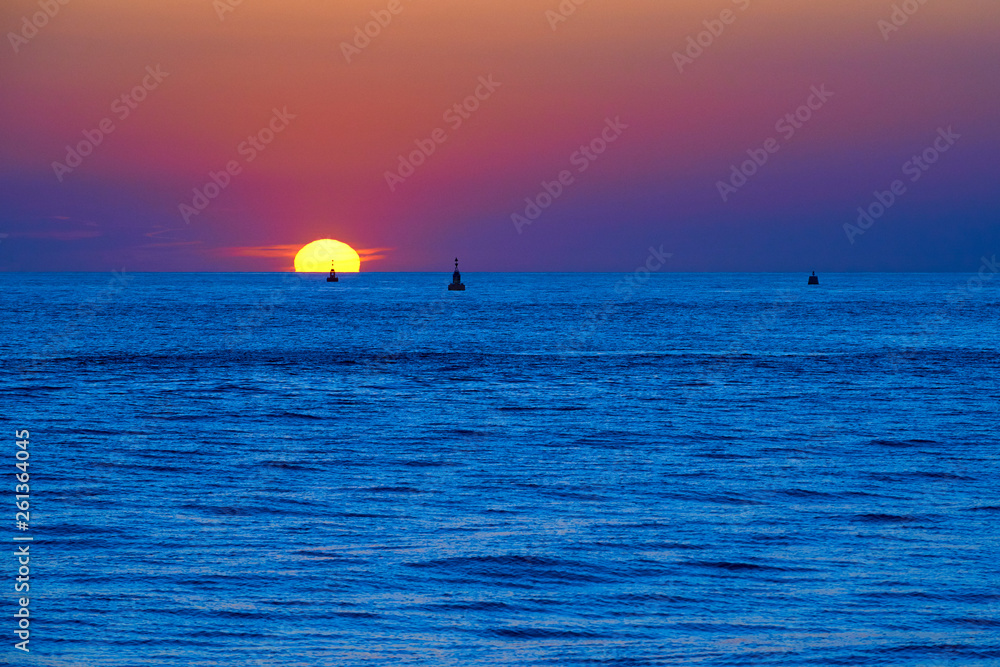 Sun sinking into the sea. Amazing sunset by the sea. The sun is about to go down behind the sea Sun sinking into the sea. Amazing sunset by the sea. The sun is about to go down behind the sea