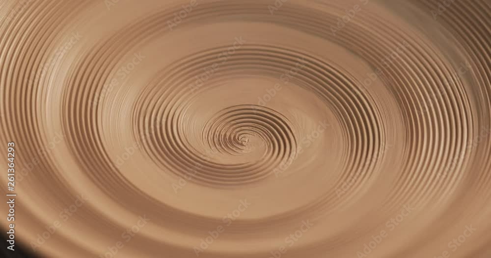 An empty plate with relief rotates on the pottery wheel, close up. Winding clay structure. Handmade, craft. White clay. Top view. An empty plate with relief rotates on the pottery wheel, close up. Winding clay structure. Handmade, craft. White clay. Top view.