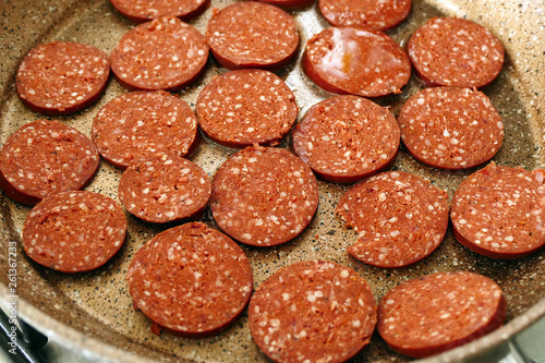 sliced sausage in the frying pan ready for flushing,close up,
