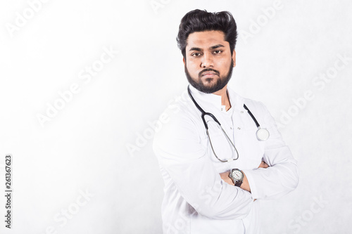 Handsome young doctor in a white coat with a stethoscope. Health care concept.