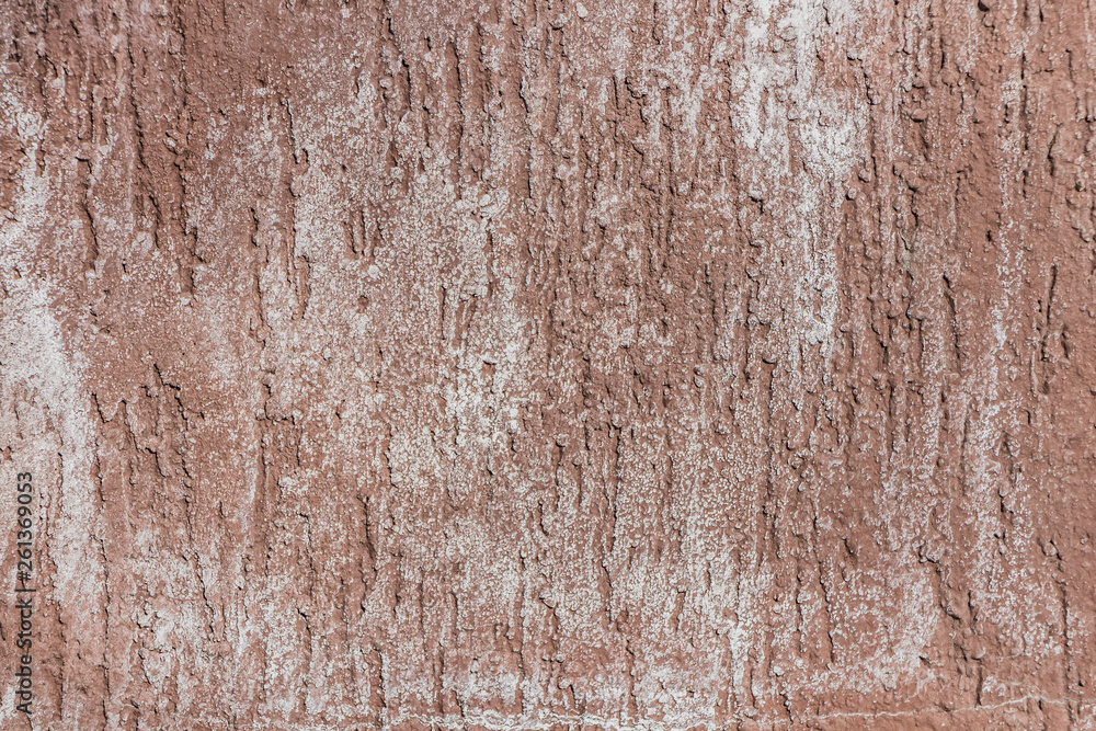A beautiful horizontal texture of part of wall with white and orange and brown plaster on the photo