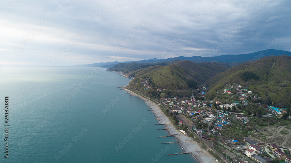 Beautiful aerial view of a coastal settlement at evening. Golovinka, Sochi. view of the highest bridge in Russia. serpentine in the mountains 