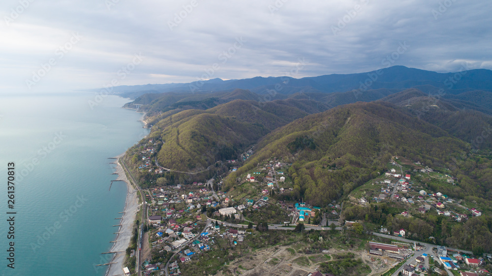 Beautiful aerial view of a coastal settlement at evening. Golovinka, Sochi. view of the highest bridge in Russia. serpentine in the mountains 