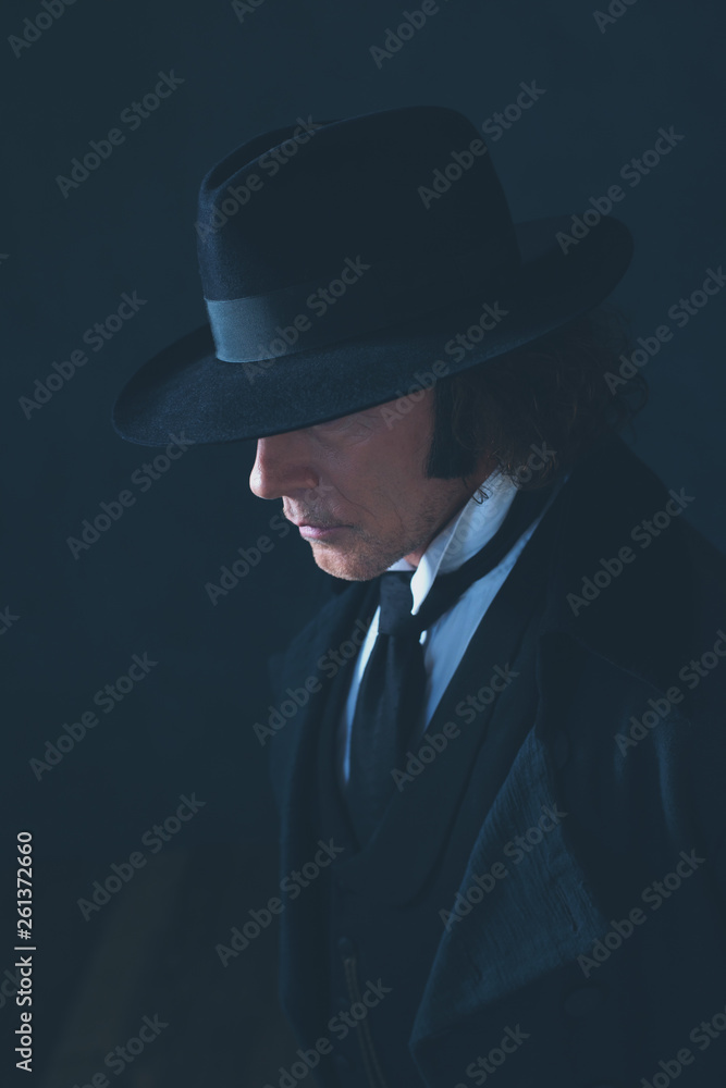 Mysterious victorian man in black coat and hat. Mysterious victorian man in black coat and hat.
