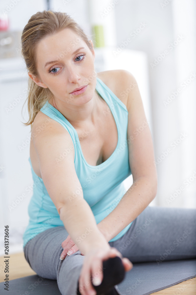 fit woman stretching legs at home
