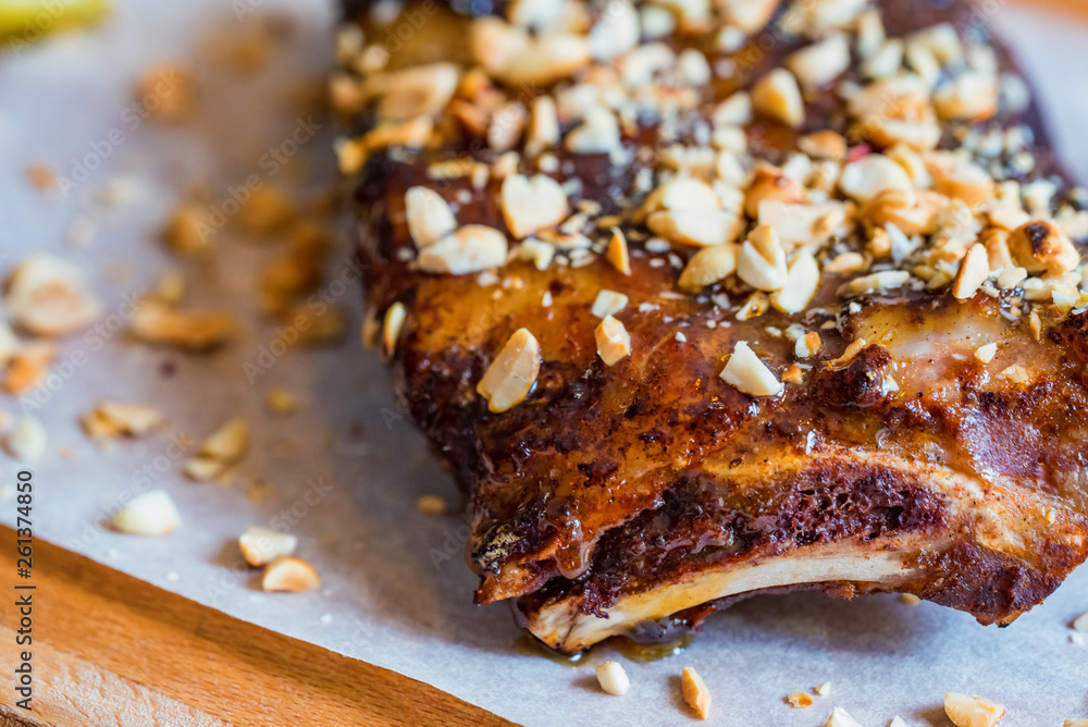 Close up board with pork ribs grilled with BBQ sauce and peanuts Close up board with pork ribs grilled with BBQ sauce and peanuts