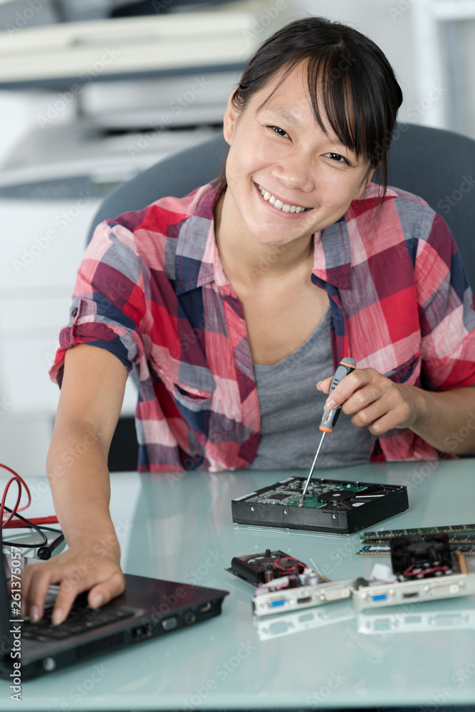 happy woman fixing external hard drive