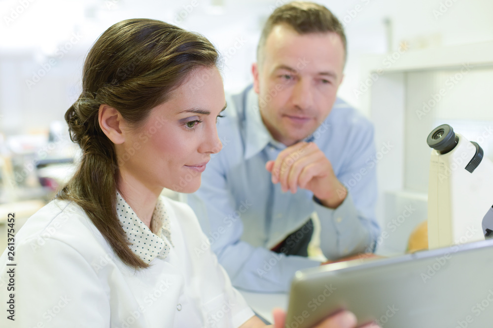 colleagues in a laboratory looking at a tablet colleagues in a laboratory looking at a tablet