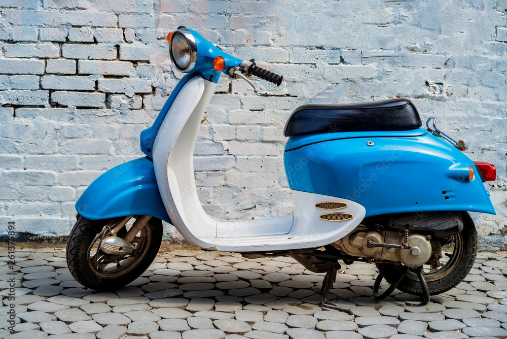 Blue retro scooter parked on city street