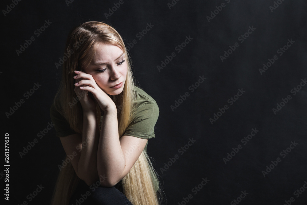 Sad young woman going to cry in a black background Sad young woman going to cry in a black background