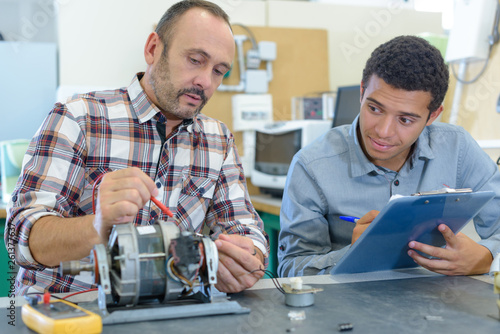 man with apprentice working mechanical