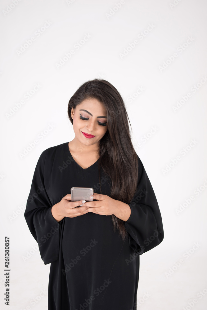 Arab woman in traditional dress using cell phone on white background Arab woman in traditional dress using cell phone on white background
