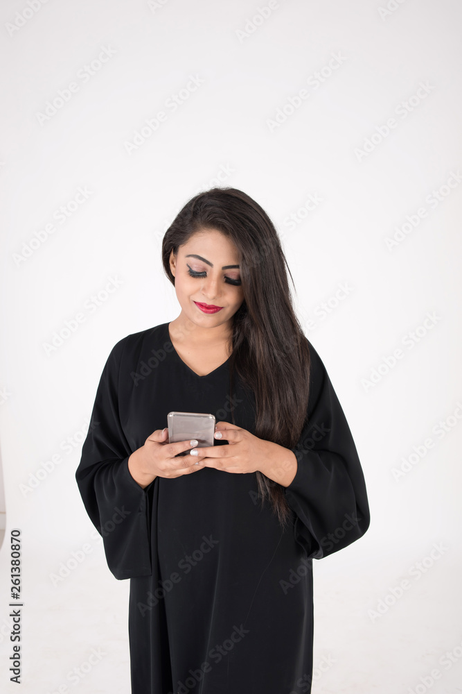 Arab woman in traditional dress using cell phone on white background Arab woman in traditional dress using cell phone on white background