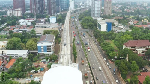 JAKARTA, Indonesia - April 08, 2019: Aerial view of Jakarta MRT stop in Fatmawati station beside toll road. Shot in 4k resolution from a drone flying backwards photo