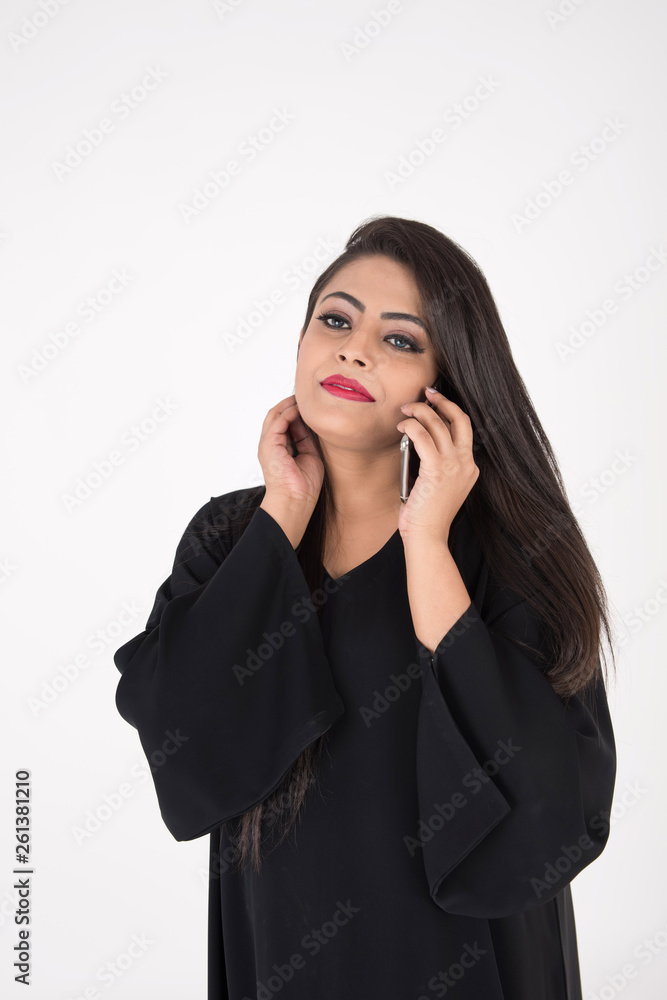 Arab woman in traditional dress using cell phone on white background Arab woman in traditional dress using cell phone on white background