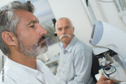optometrist doing sight testing for senior patient