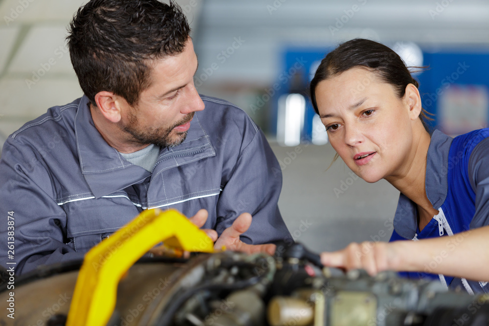 Fotografie trainee of car-service mechanic listening to manager