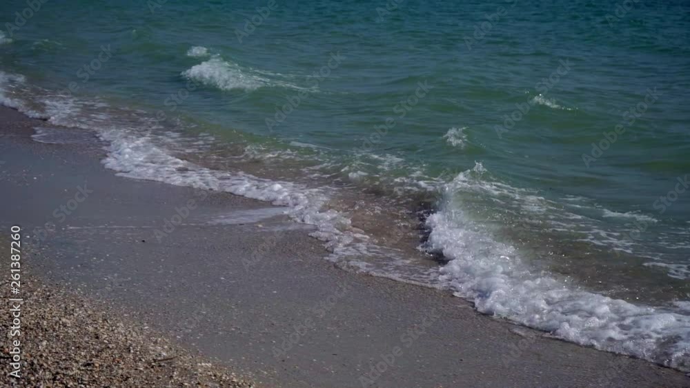 Slow motion. Sea waves with foam in windy weather in spring by the sea. Resort town in the off season. Breakwater in the distance Slow motion. Sea waves with foam in windy weather in spring by the sea. Resort town in the off season. Breakwater in the distance