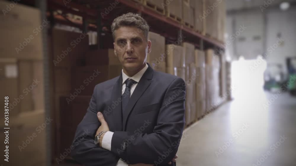 Medium shot of portrait of businessman standing with arms crossed in warehouse Medium shot of portrait of businessman standing with arms crossed in warehouse