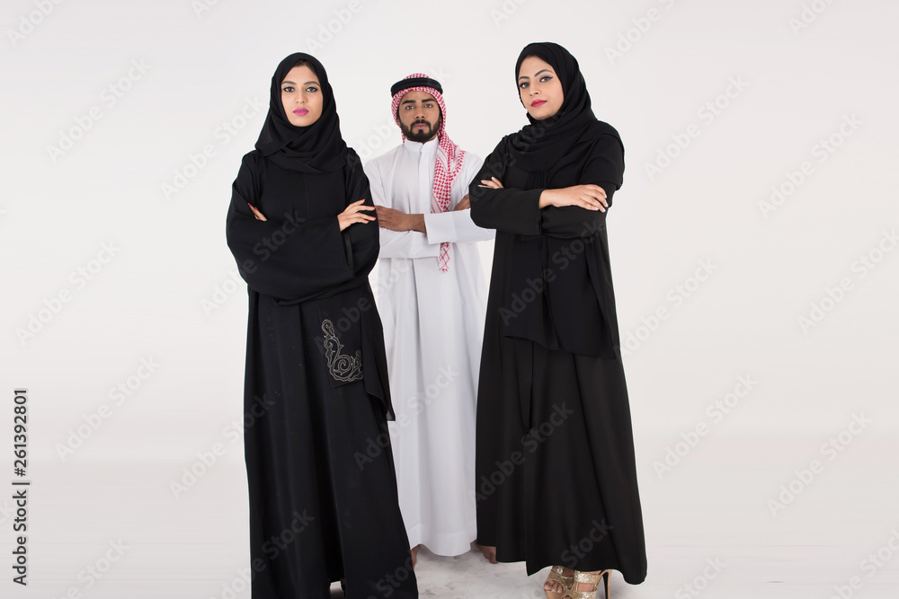 Two arab females with one male smiling and standing on white background