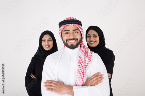Two arab females with one male smiling and standing on white background