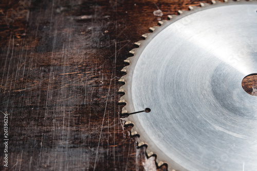 Close-up blade circular saw on the background of the wooden table. Workshop for the production of wooden products. Joiner's cutting tool