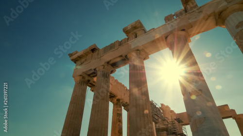 Sun shines between the columns of the Parthenon at the Acropolis in Athens, Greece