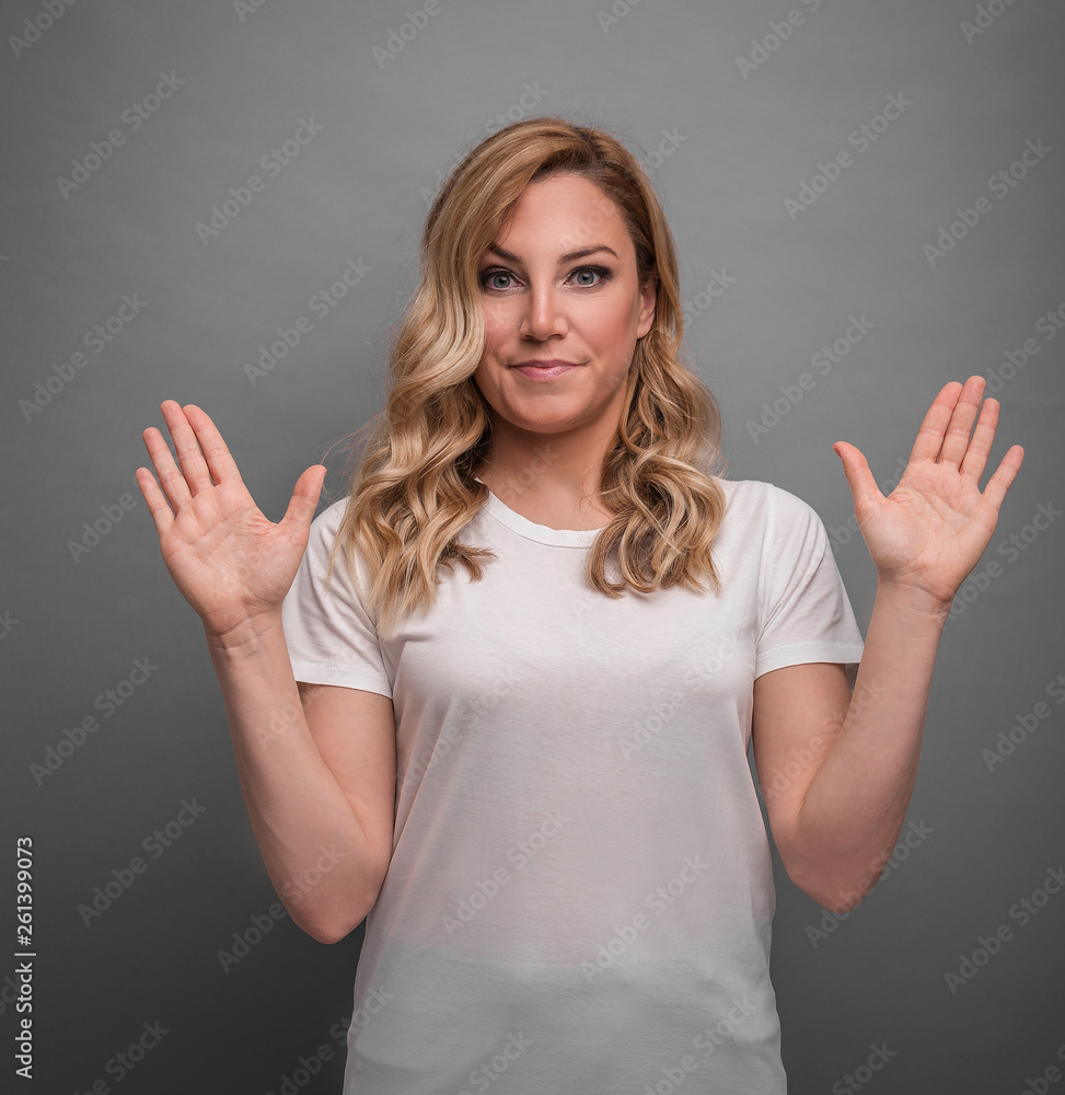 Young woman raises her hands up showing surprise or denial. Young woman raises her hands up showing surprise or denial.