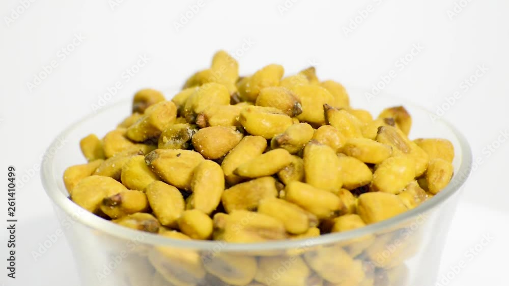 Transparent glass bowl with toasted salted corns rotating on a white background. Flat plane. High angle shot Transparent glass bowl with toasted salted corns rotating on a white background. Flat plane. High angle shot