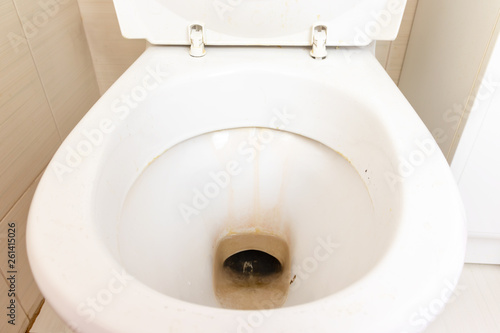 Dirty unhygienic toilet bowl with limescale stain at public restroom close up