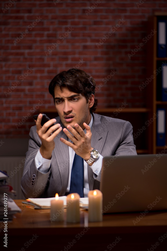Businessman working late in office with candle light Businessman working late in office with candle light