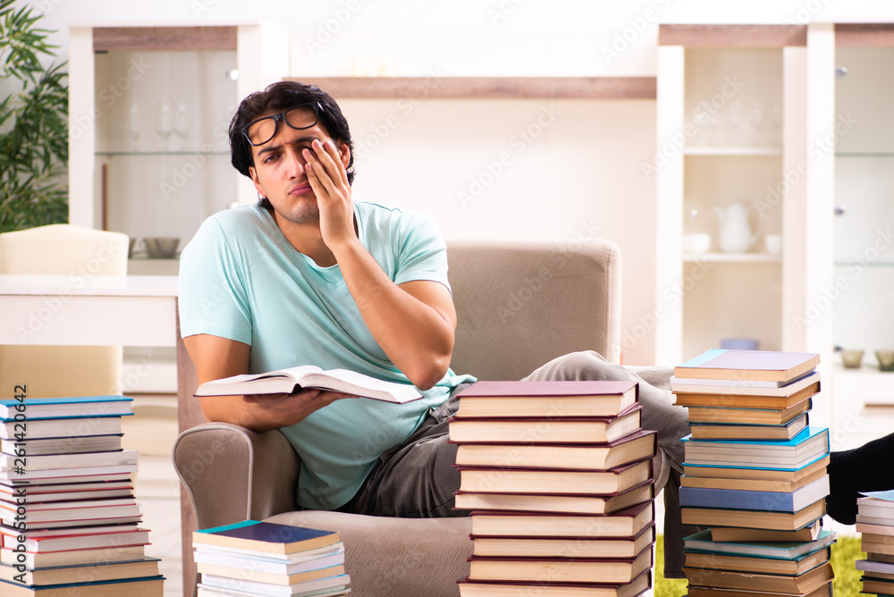 Male student with many books at home Male student with many books at home