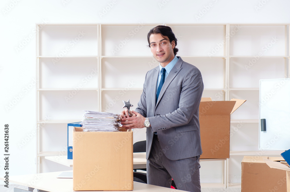Young man employee with boxes in the office Young man employee with boxes in the office